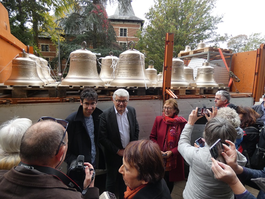 Burgemeester Andre Peeters poseert bij de nieuwe klokken